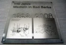 Medizinische Jubiläumstafel mit historischen und aktuellen Bildern.