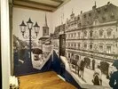 Historische Straßenszene mit Pferdekutschen und Gebäuden, dargestellt auf zwei angrenzenden Wänden als Textildruck.